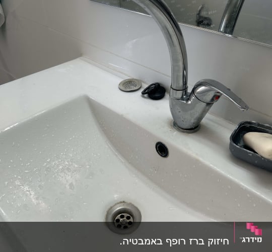 ברז וכיור בחדר אמבטיה עם סבון
